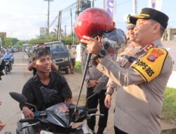 Pendekatan Holistik, Polres Kutim Bagi Helm dan Bunga Untuk Pengguna Jalan
